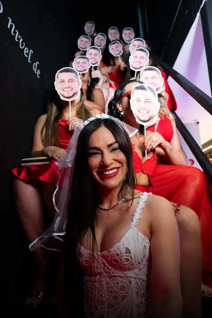 Amigas segurando plaquinhas com o rosto do noivo